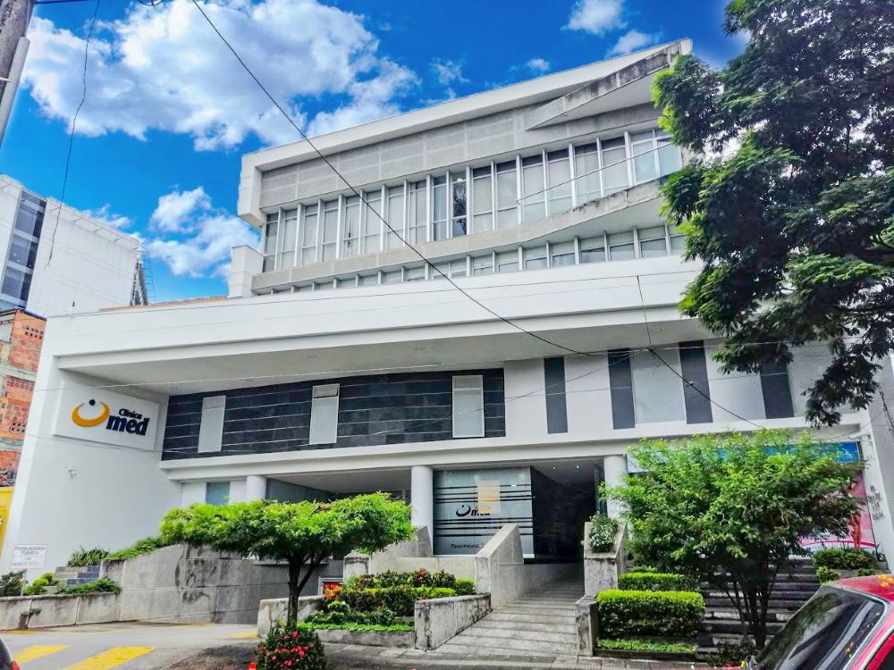Profesional de salud en bata blanca revisando equipos médicos de alta tecnología en quirófano de Clínica Med en Cali, Colombia