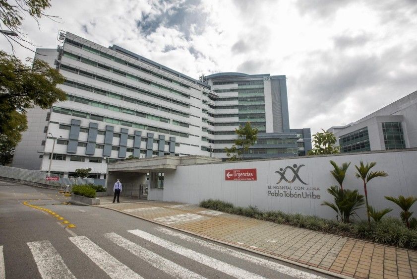 Médico especialista revisando resultados de diagnóstico con paciente en consulta privada dentro de las instalaciones del Hospital Pablo Tobón Uribe en Medellín