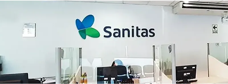 Médico de EPS Sanitas atendiendo a un paciente adulto en consultorio de una clínica afiliada en Perú