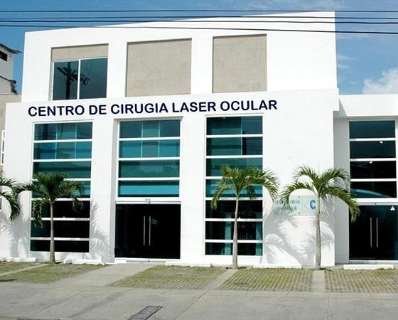 Paciente recostado en silla quirúrgica recibiendo evaluación preoperatoria con equipo de topografía corneal en consulta de oftalmología en Cartagena