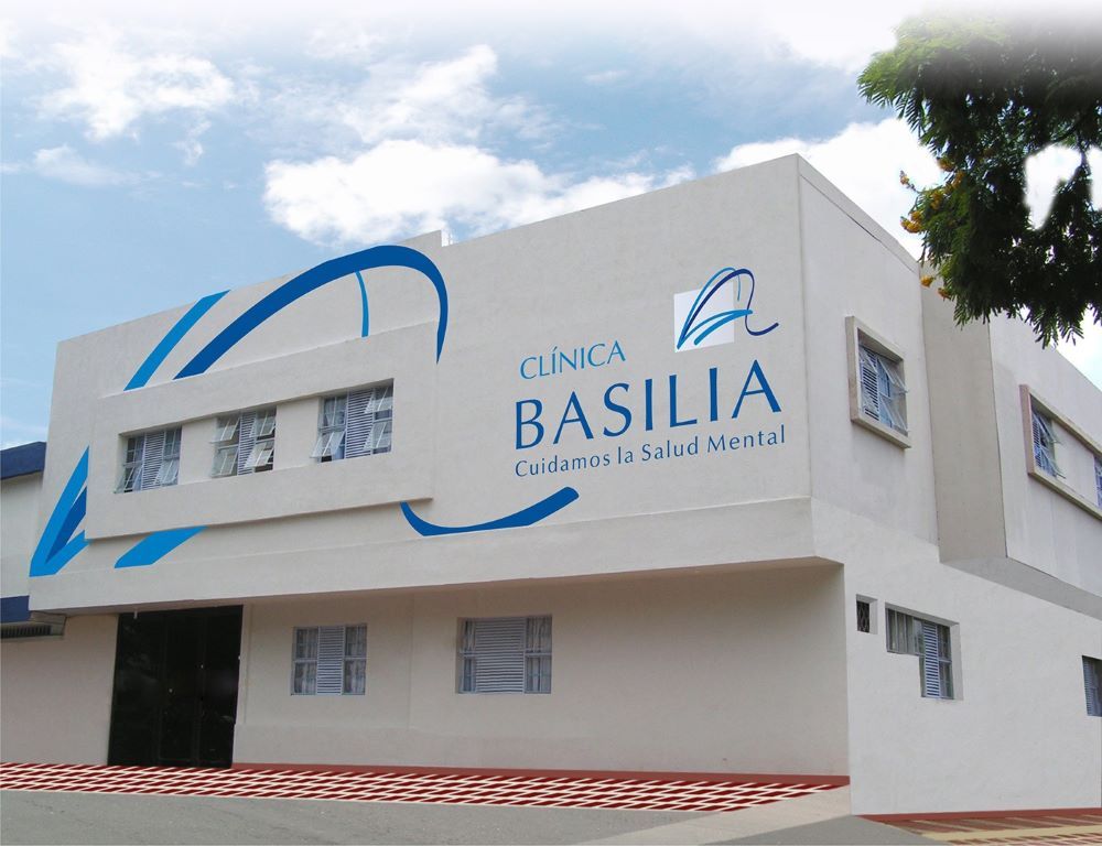 Profesional de salud mental en consulta con un paciente adulto en un consultorio clínico tranquilo y bien iluminado de la Clínica Basilia en Cali, Colombia