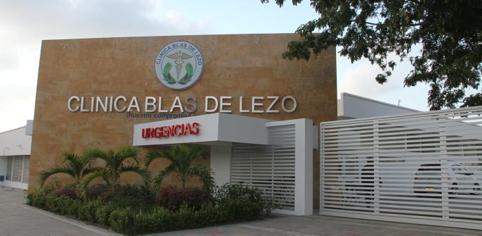 Pasillo de la Clínica Blas de Lezo en Cartagena con personal de salud atendiendo a un paciente en camilla rumbo a urgencias