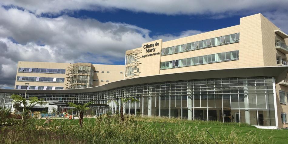 Médico especialista revisando imágenes diagnósticas con un paciente en una consulta privada dentro de una clínica de alta complejidad en Bogotá