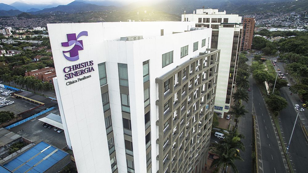 Médico especialista revisando resultados de imágenes diagnósticas junto a un paciente en una sala de consulta moderna de la Clínica Farallones en Cali, Colombia