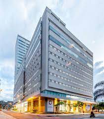 Médico especialista revisando resultados de diagnóstico junto a un paciente en una habitación de hospitalización de la Clínica del Prado en Medellín