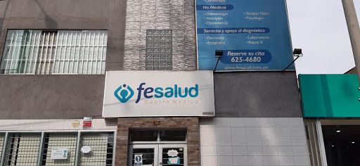 Médico especialista de Clínica Fesalud realizando una consulta virtual con un paciente desde una plataforma digital, con equipamiento médico visible en el consultorio